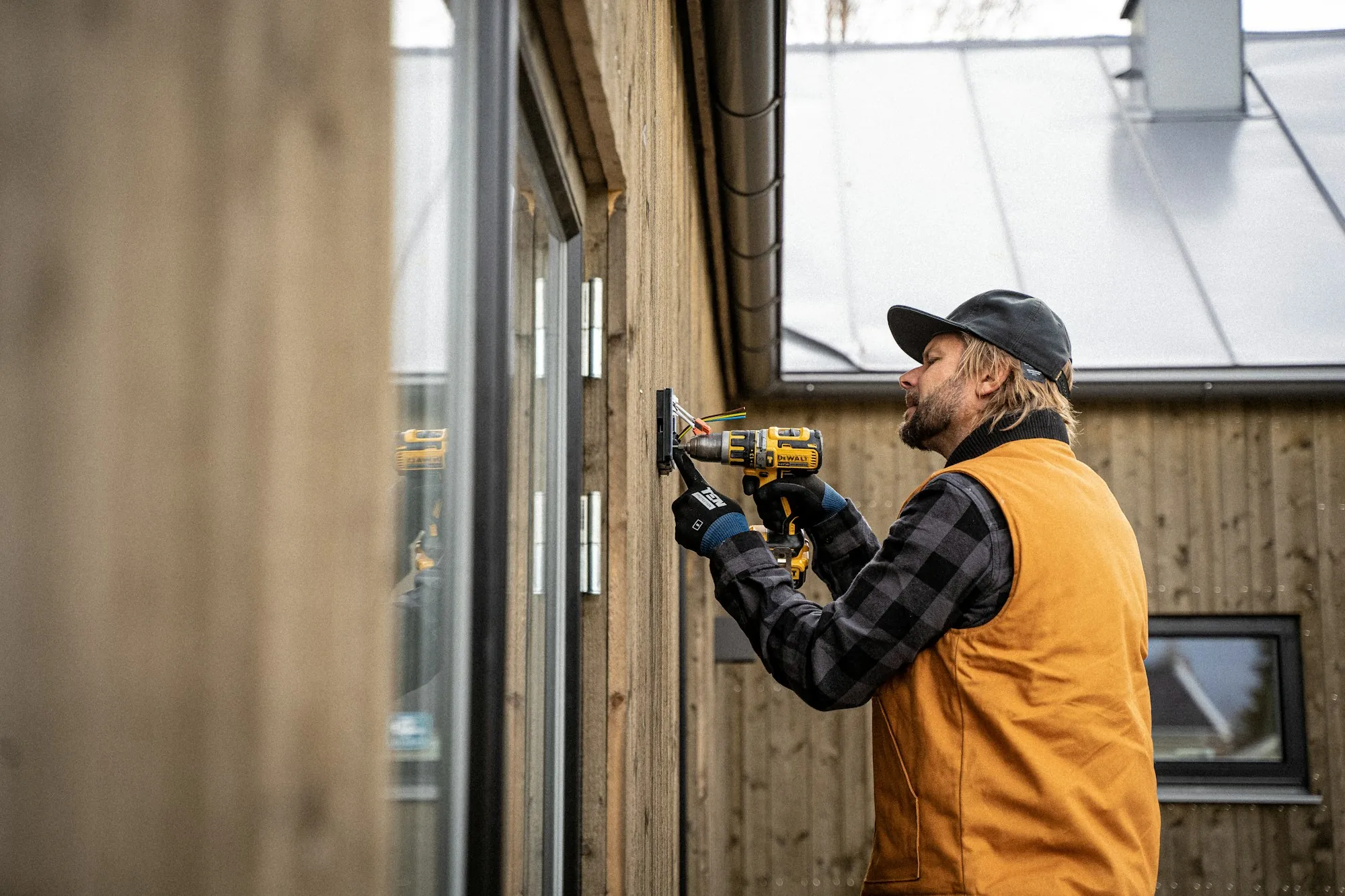 Electrician using a power drill while working on a wall