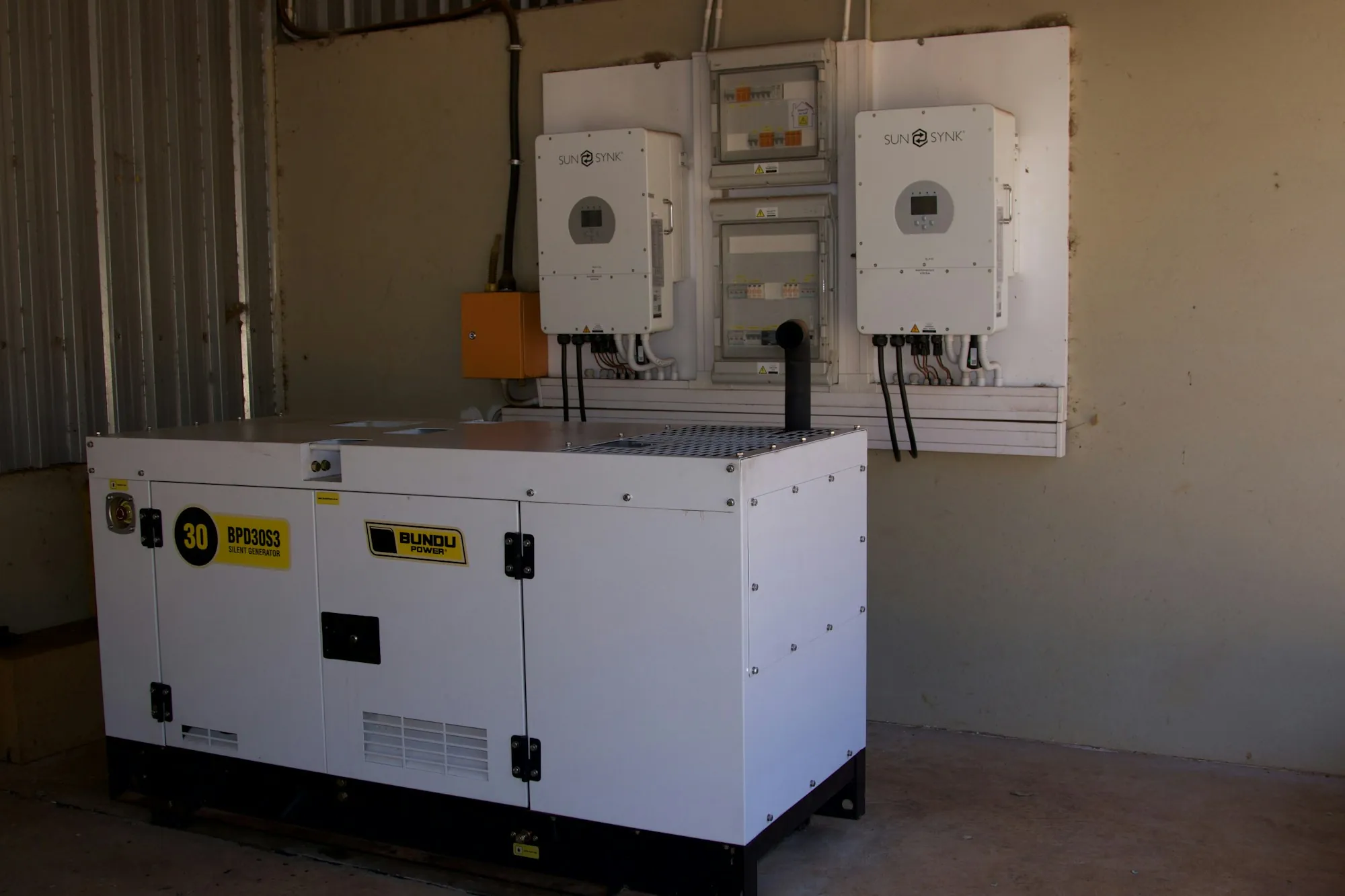 Standby generator installed beside wall-mounted power equipment