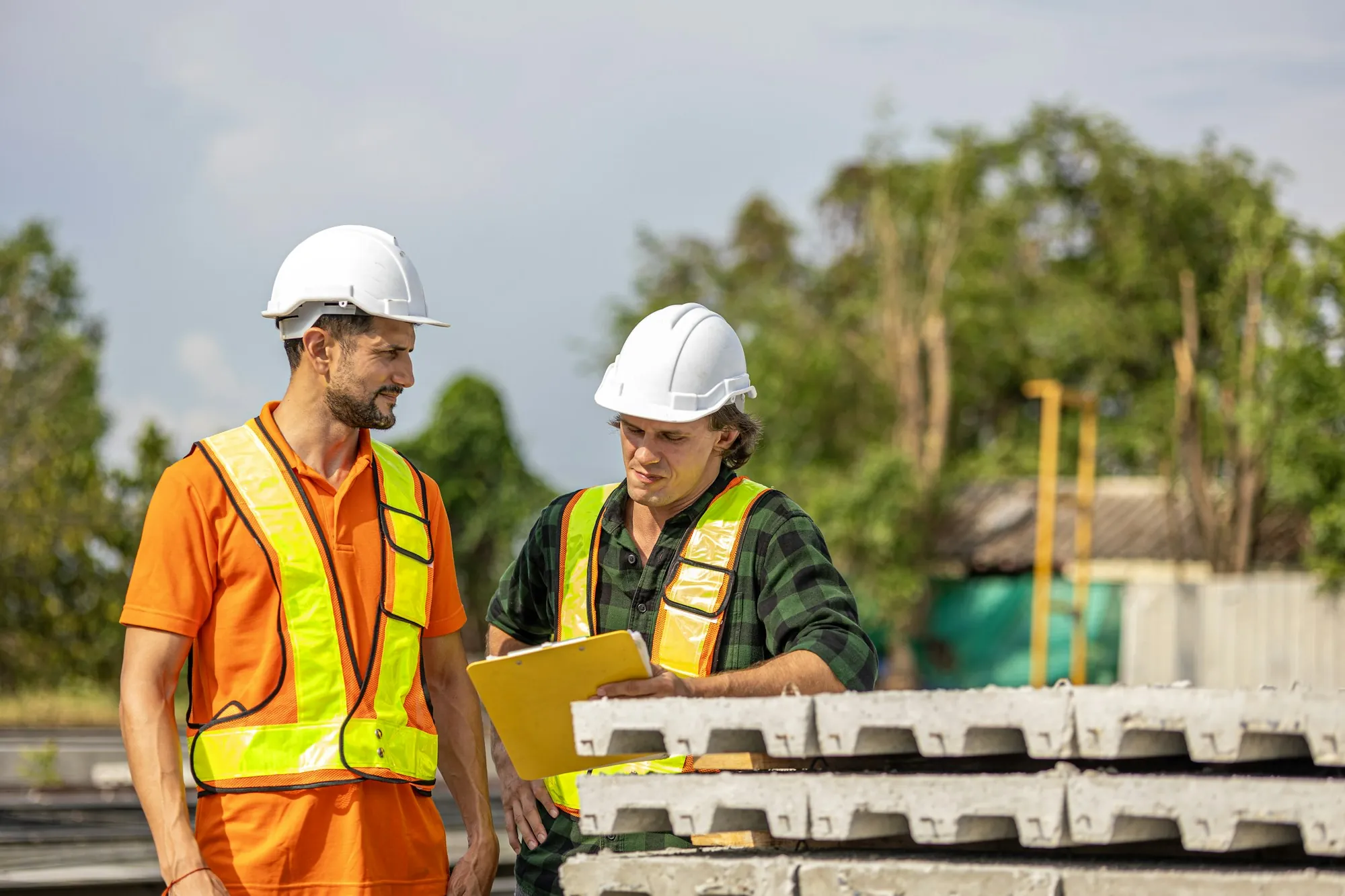 Two tradespeople reviewing job plans together on site