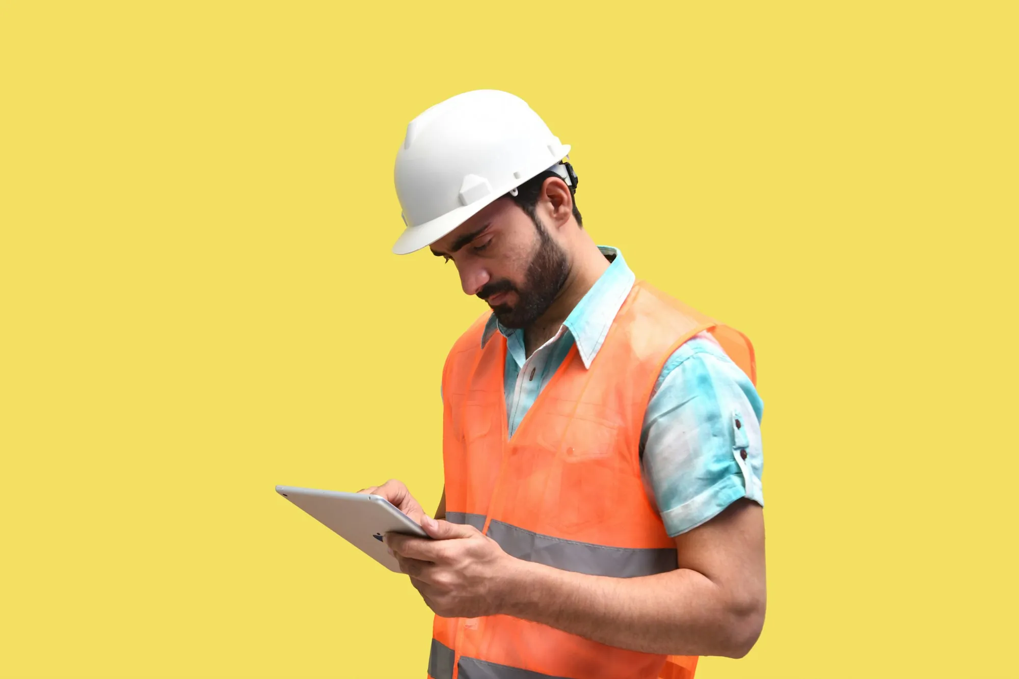 Inspector in a hard hat reviewing findings on a tablet at a job site