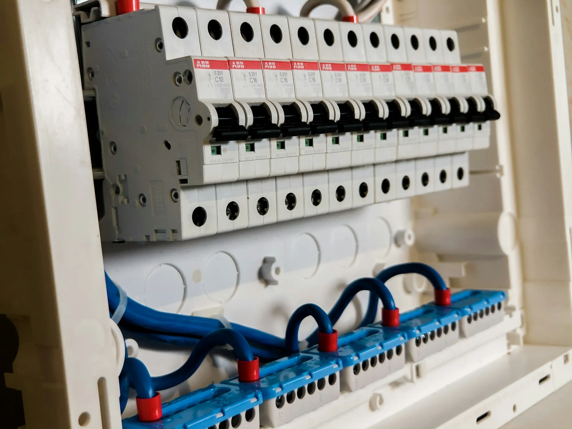 Row of white circuit breakers inside a residential panel