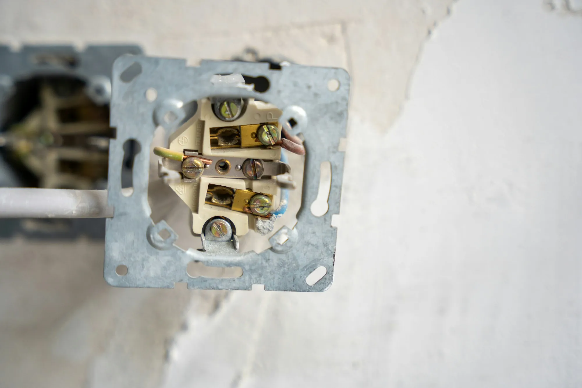 Electrical outlet pulled from the wall box with its wiring exposed